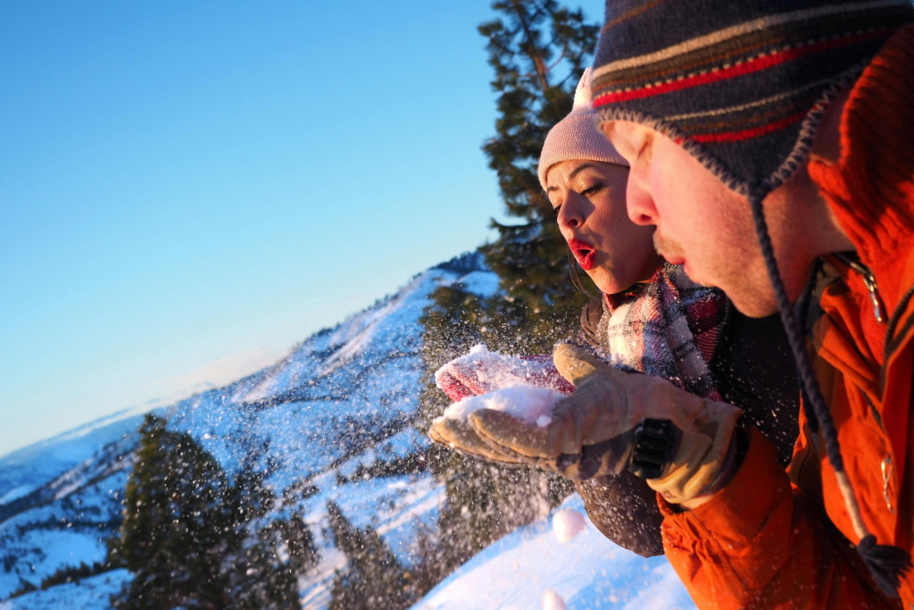 ein Paar pustet Schnee von den Händen