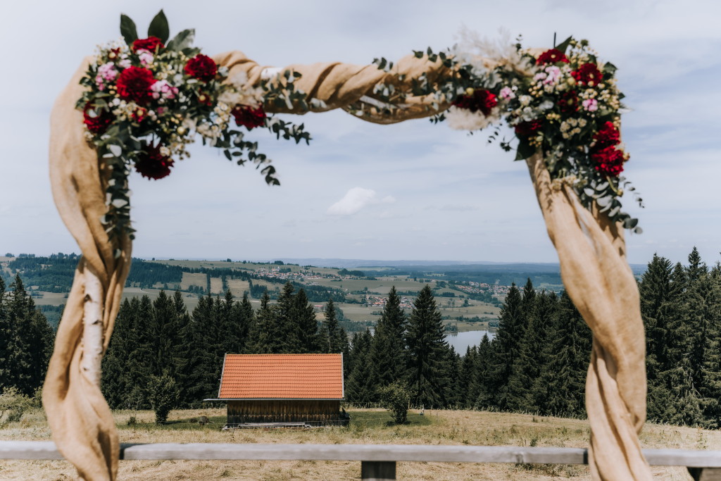 Blumengeschm&uuml;ckter Traubogen vor Bergkulisse